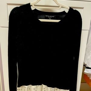Black sweater with white and black stars on the bottom.